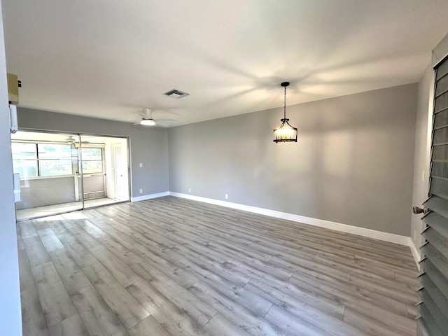 spare room featuring a ceiling fan, baseboards, visible vents, and light wood finished floors