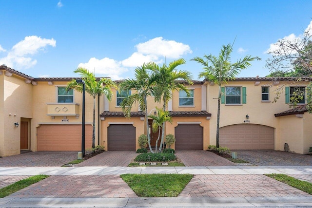 4607 Mediterranean Cir, Palm Beach Gardens, FL 33418 - view of front facade featuring a garage, driveway, a tiled roof, and stucco siding