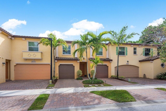 townhome / multi-family property with driveway, an attached garage, and stucco siding