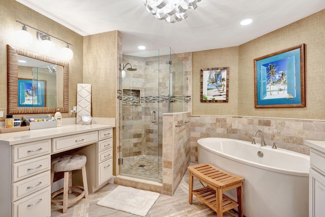 bathroom featuring a freestanding tub, a shower stall, vanity, and tile walls