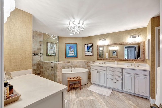 bathroom with a soaking tub, a shower stall, tile walls, and a sink