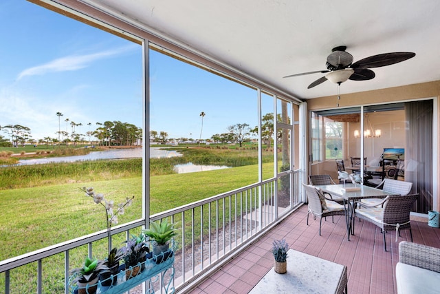 sunroom / solarium with a water view and a ceiling fan