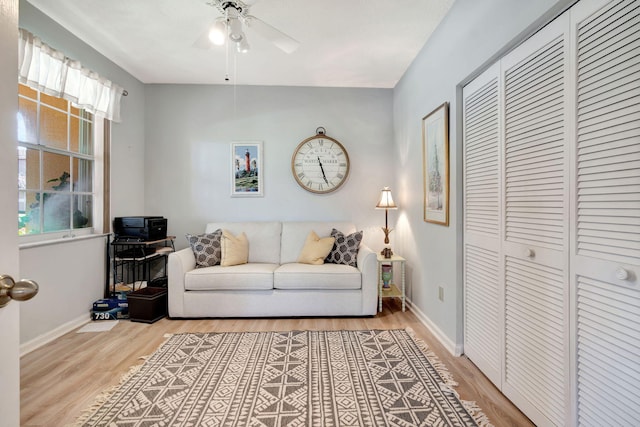 living area featuring light wood finished floors, ceiling fan, and baseboards