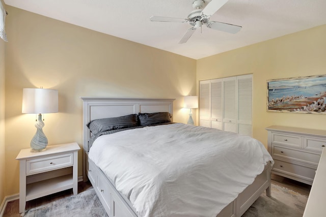 bedroom with light wood-style floors, ceiling fan, baseboards, and a closet