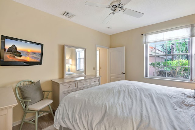 bedroom with visible vents, ceiling fan, baseboards, and wood finished floors