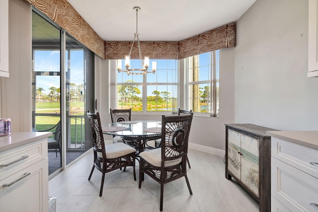 dining space with baseboards and a notable chandelier