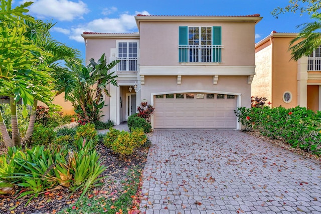 view of front of property featuring decorative driveway, an attached garage, and stucco siding