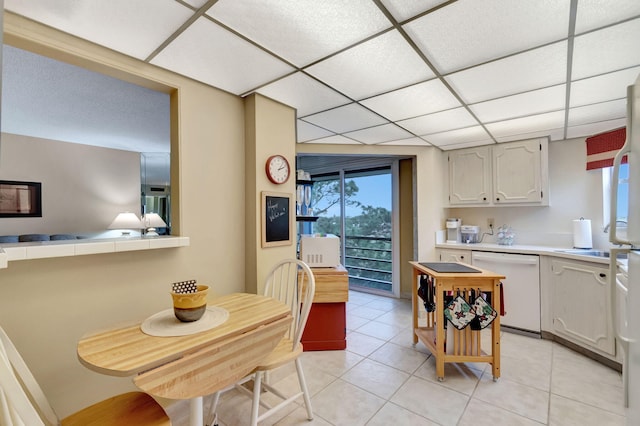 kitchen featuring a paneled ceiling, light countertops, dishwasher, and light tile patterned floors