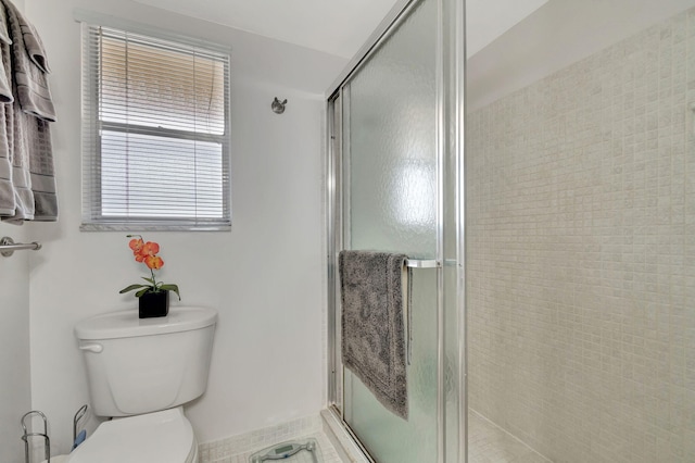 bathroom featuring toilet and a stall shower