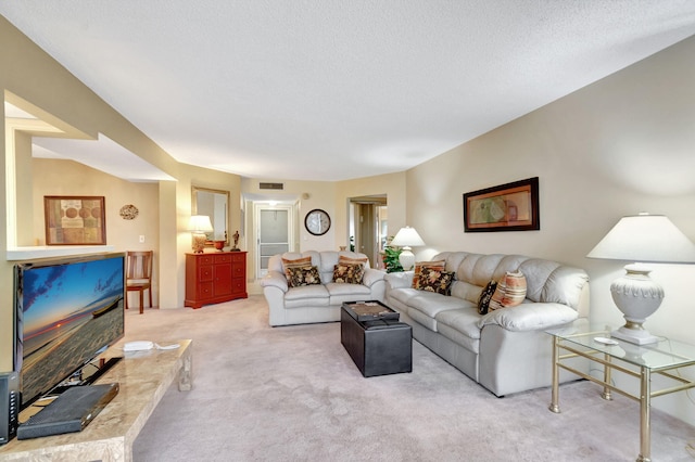 living area with visible vents, light carpet, and a textured ceiling