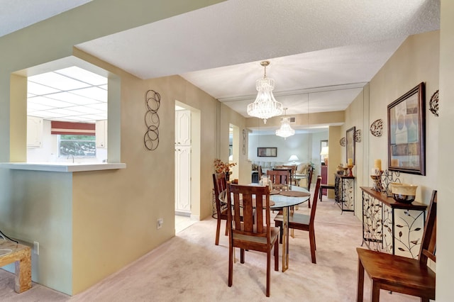 dining area featuring an inviting chandelier and light colored carpet