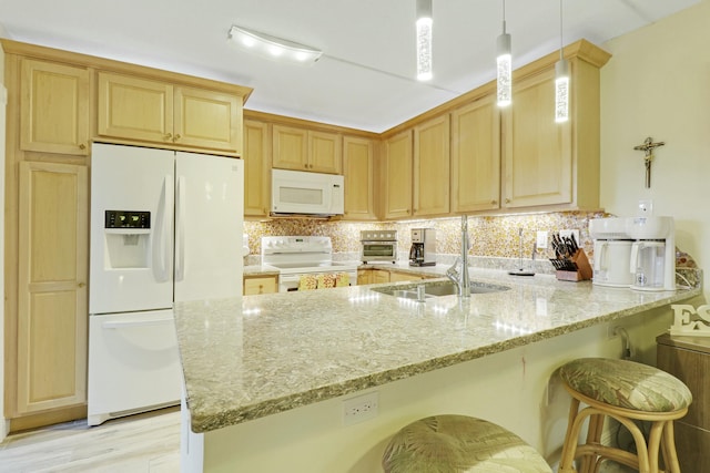 kitchen with light stone counters, white appliances, a peninsula, and tasteful backsplash