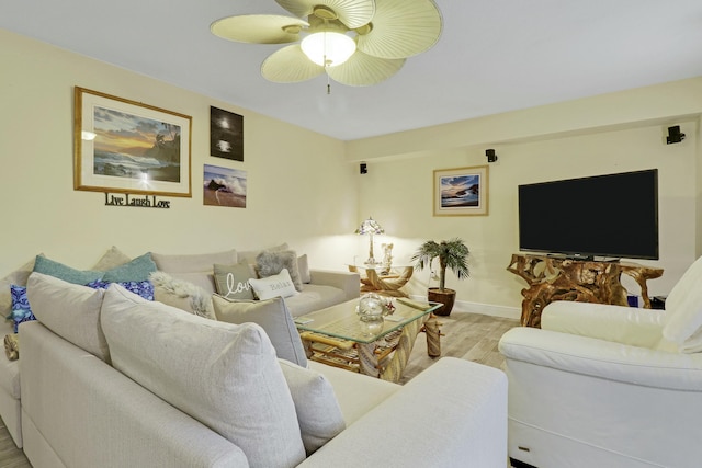 living room featuring wood finished floors, a ceiling fan, and baseboards