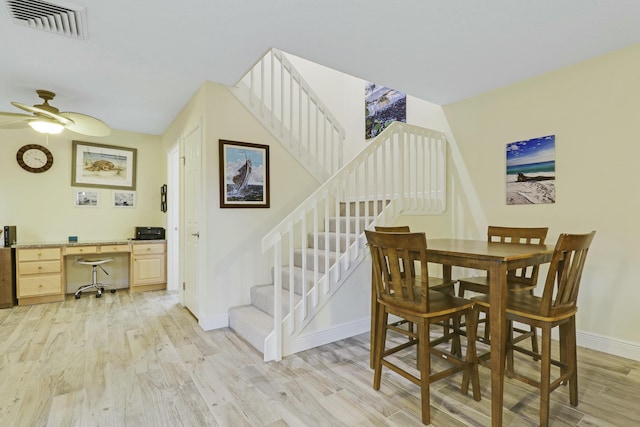 dining space with visible vents, baseboards, built in study area, light wood-style flooring, and stairway