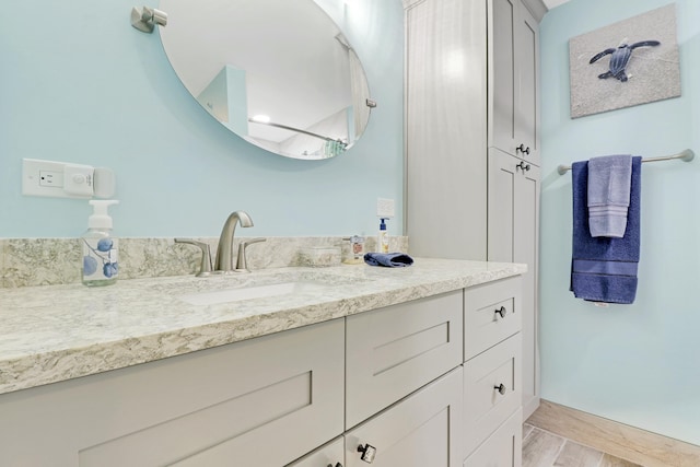 bathroom with baseboards, wood finished floors, and vanity