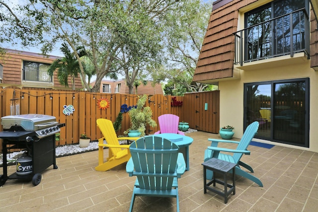 view of patio / terrace featuring a grill, a balcony, and fence