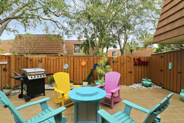 view of patio with a gate, fence, and area for grilling