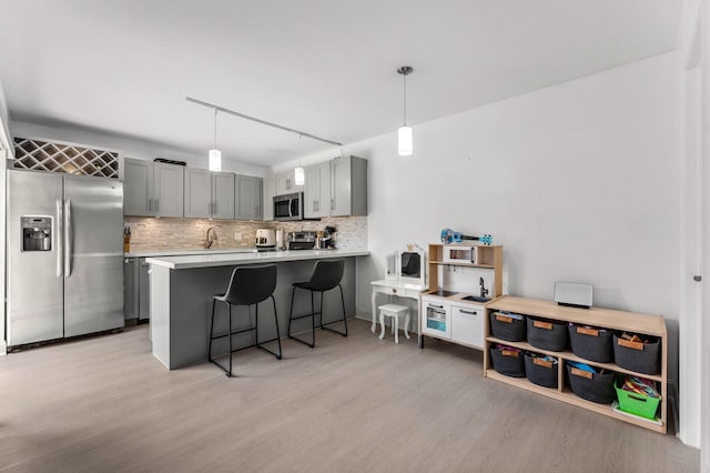 9965 NW 6th Ct, Plantation, FL 33324 - kitchen featuring stainless steel appliances, a peninsula, light countertops, and decorative light fixtures