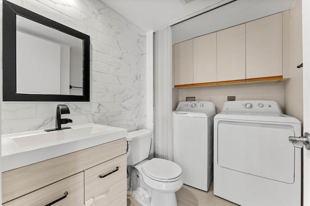 9965 NW 6th Ct, Plantation, FL 33324 - half bathroom featuring toilet, wood finished floors, washing machine and clothes dryer, vanity, and tile walls