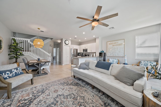 living area with light tile patterned floors, recessed lighting, visible vents, a ceiling fan, and stairway