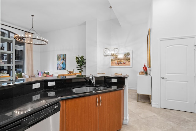 kitchen featuring dishwasher, dark stone counters, pendant lighting, and a sink