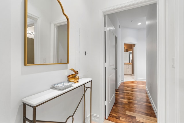 hallway with wood finished floors and baseboards