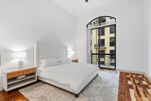 bedroom featuring lofted ceiling, ceiling fan, wood finished floors, baseboards, and access to exterior