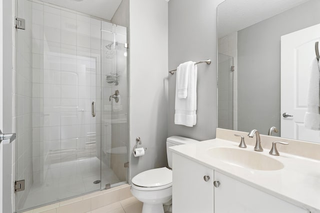 bathroom with a shower stall, toilet, and vanity