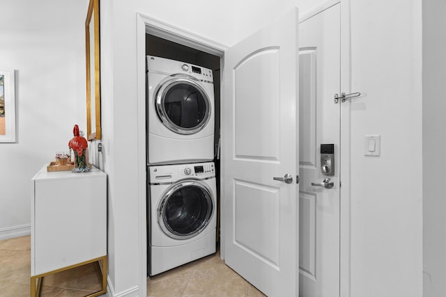 laundry area with laundry area, light tile patterned floors, and stacked washer / drying machine