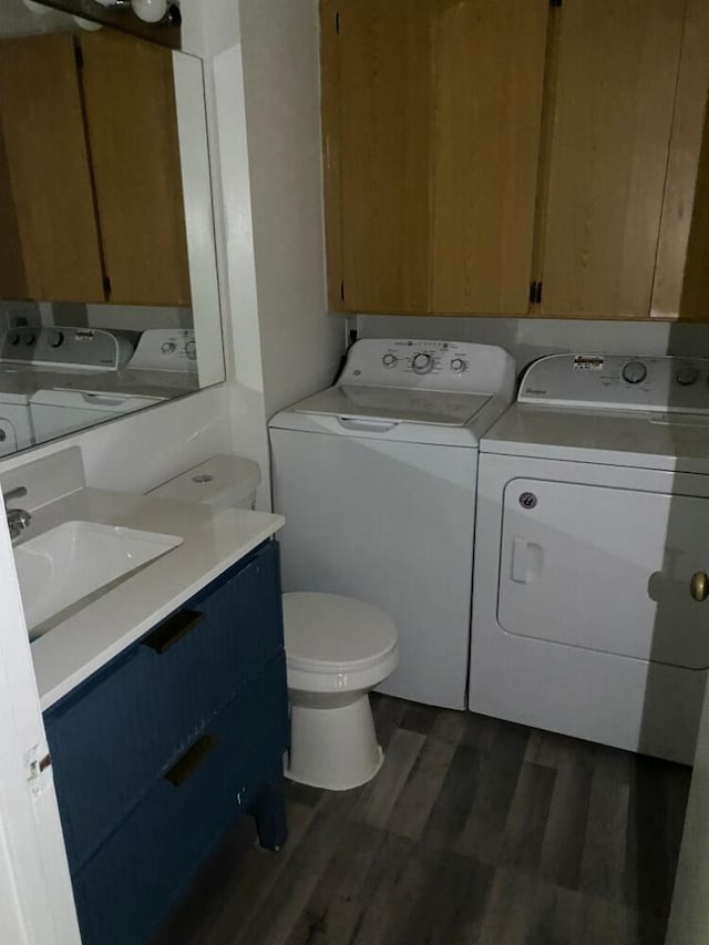 laundry area with dark wood-style floors, washer and dryer, laundry area, and a sink