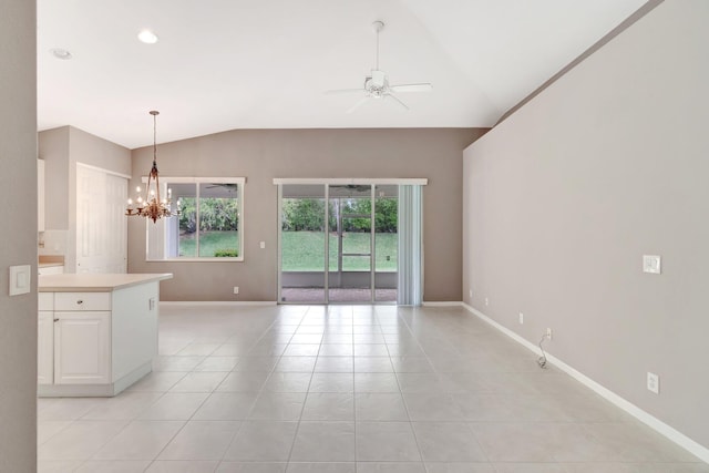 interior space with lofted ceiling, light tile patterned floors, baseboards, and ceiling fan with notable chandelier