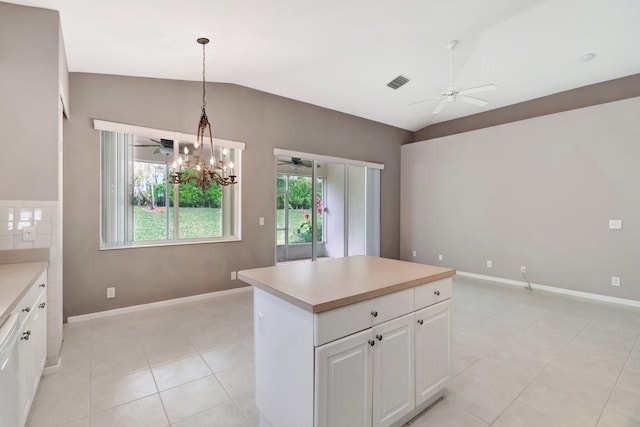 kitchen with lofted ceiling, ceiling fan with notable chandelier, visible vents, white cabinetry, and light countertops