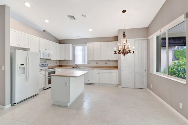 kitchen with a chandelier, white appliances, visible vents, light countertops, and a center island