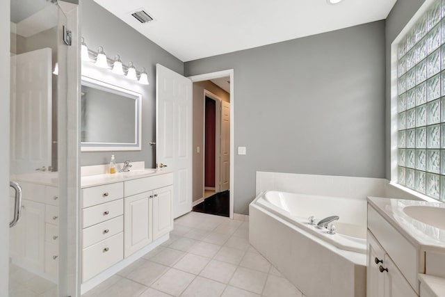 full bathroom featuring a garden tub, tile patterned flooring, two vanities, a sink, and visible vents