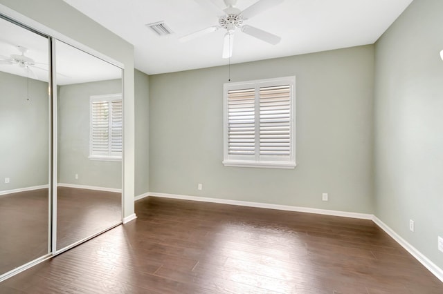 unfurnished bedroom featuring a closet, visible vents, baseboards, and wood finished floors