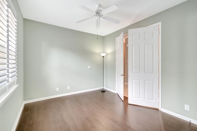 unfurnished bedroom featuring baseboards, dark wood finished floors, and a ceiling fan