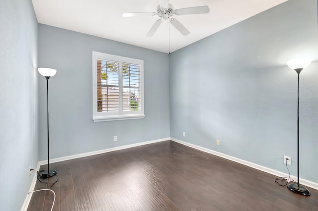 unfurnished room with ceiling fan, dark wood finished floors, and baseboards