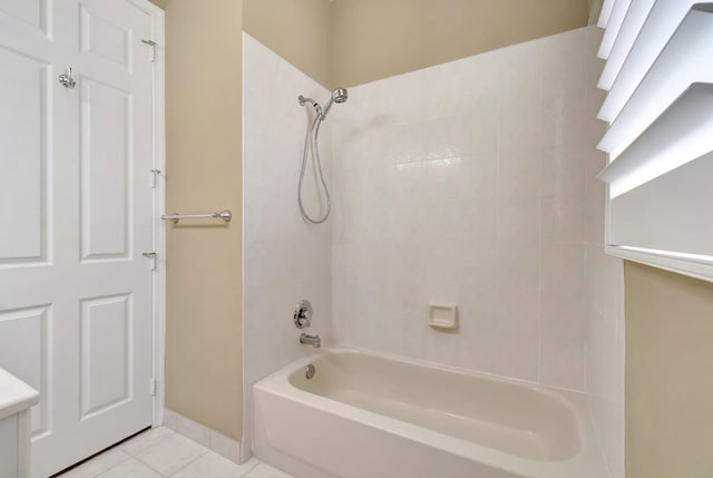 full bathroom featuring washtub / shower combination, tile patterned flooring, and baseboards