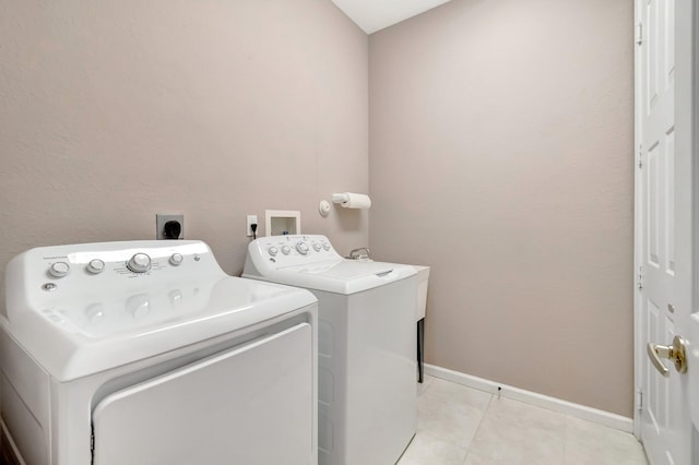 laundry area featuring laundry area, light tile patterned floors, baseboards, and independent washer and dryer