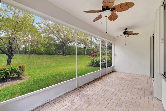 unfurnished sunroom featuring a ceiling fan