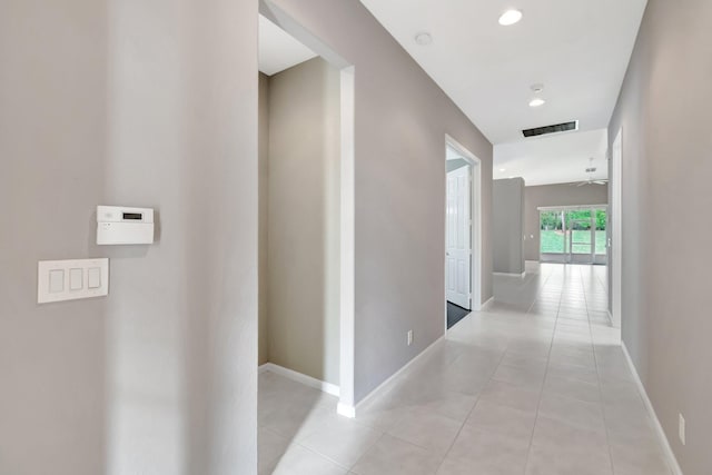 corridor featuring light tile patterned floors, recessed lighting, visible vents, and baseboards