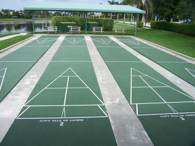 view of community with a water view, a yard, and shuffleboard