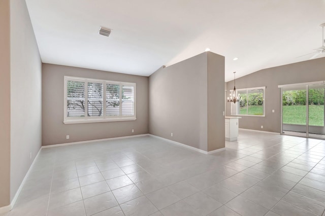 empty room with light tile patterned flooring, ceiling fan with notable chandelier, visible vents, baseboards, and vaulted ceiling