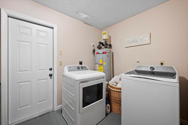 laundry area featuring water heater, laundry area, washer and clothes dryer, and a textured ceiling