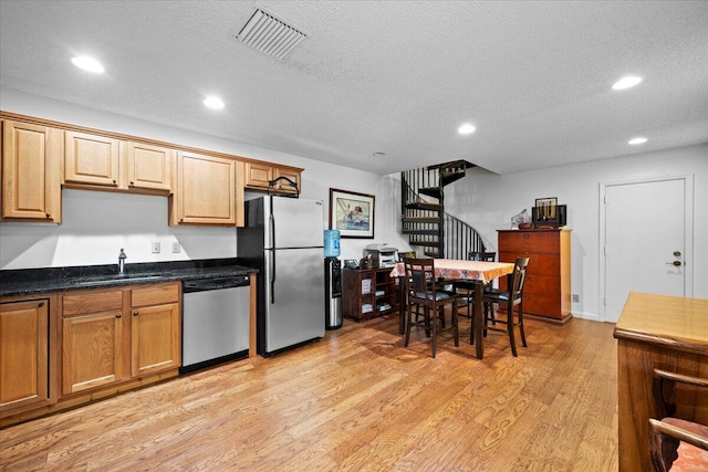 kitchen with recessed lighting, stainless steel appliances, a sink, visible vents, and light wood finished floors