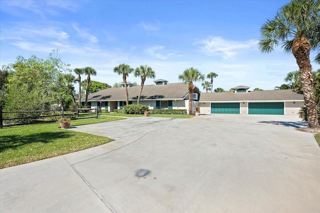 single story home featuring driveway, a garage, fence, and a front yard