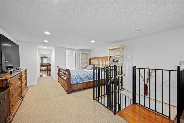 bedroom featuring a textured ceiling, recessed lighting, and light colored carpet