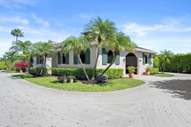 view of front of house with gravel driveway and stucco siding