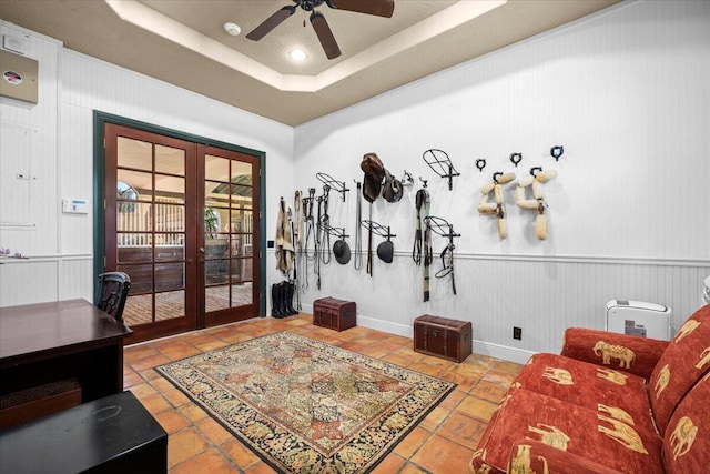 tiled living area with a tray ceiling, french doors, ceiling fan, and recessed lighting