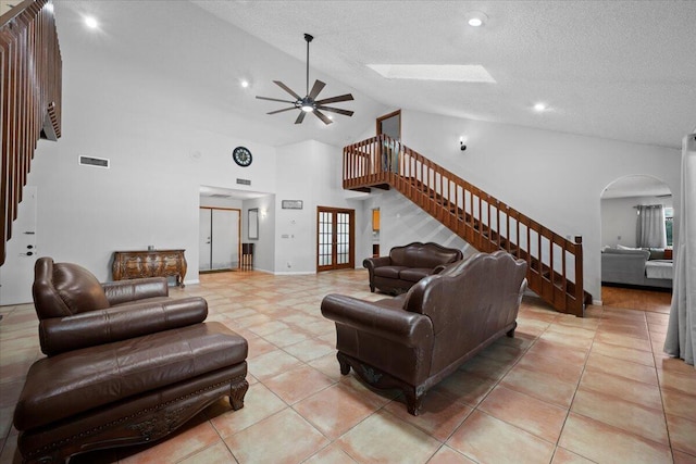 living room with arched walkways, visible vents, stairway, and light tile patterned flooring